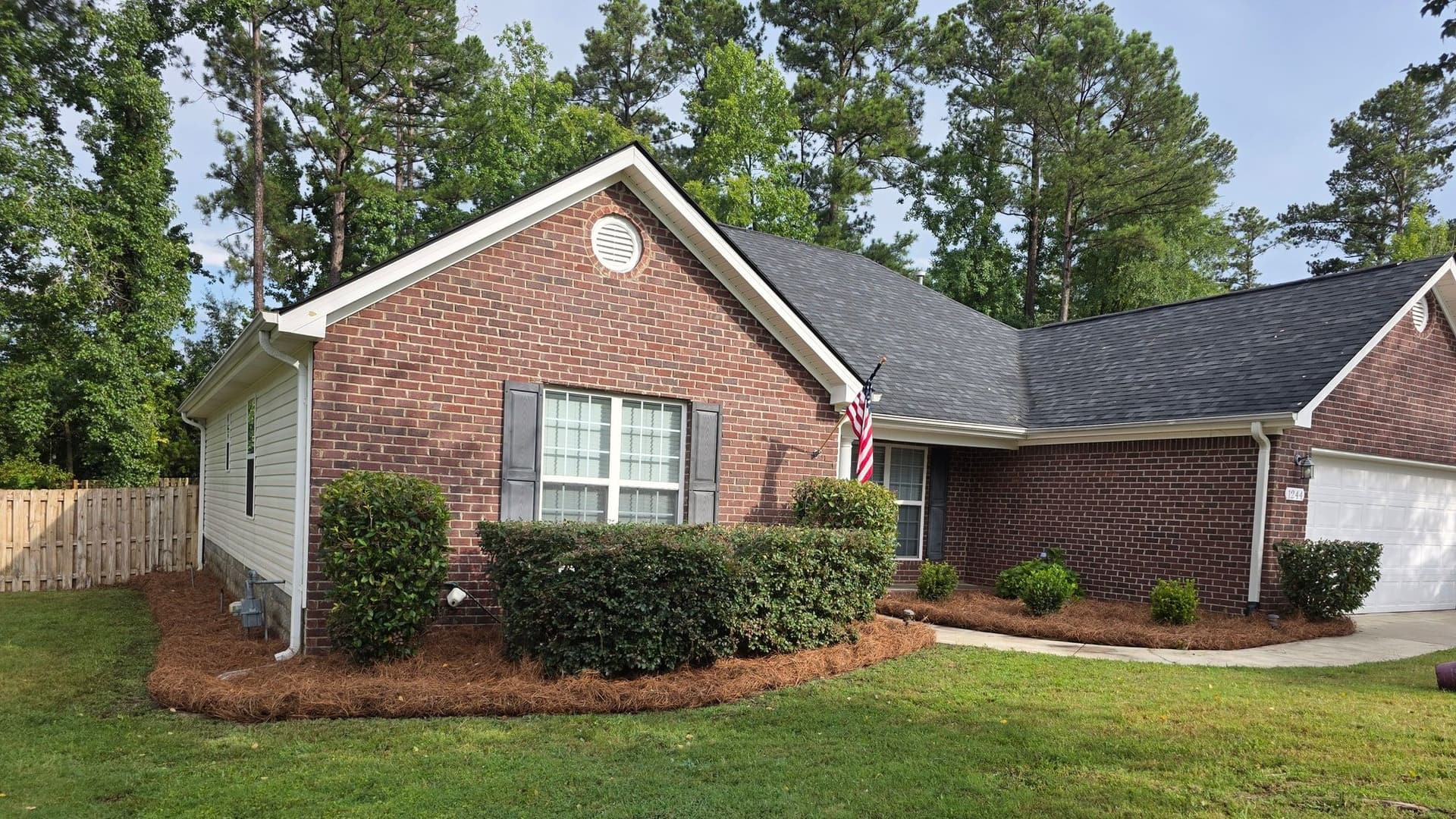Brick home, freshly cut lawn, trimmed foundation shrubs